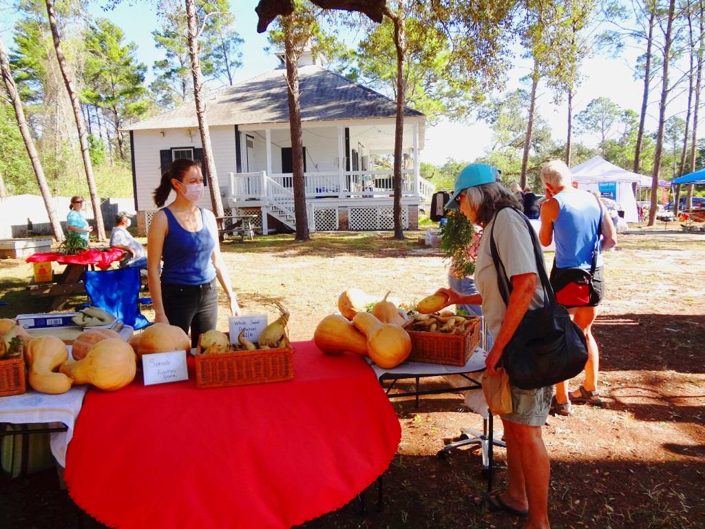 Vendor selling goods and greeting customers at the Country Market