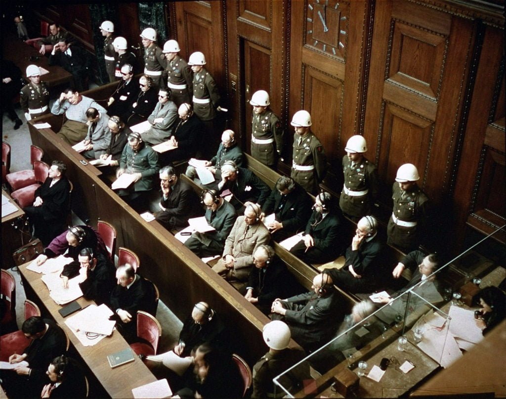 Men sitting in long rows in a courtroom