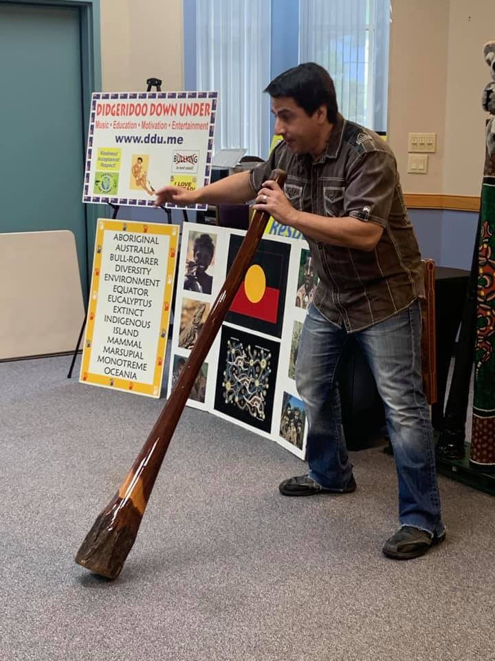 Man plays a large Didgeridoo wind instrument