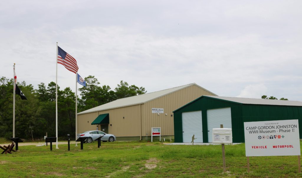 Two large metal buildings with a flag pole