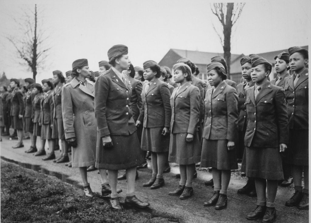African-American women in WWII uniforms stand at attention