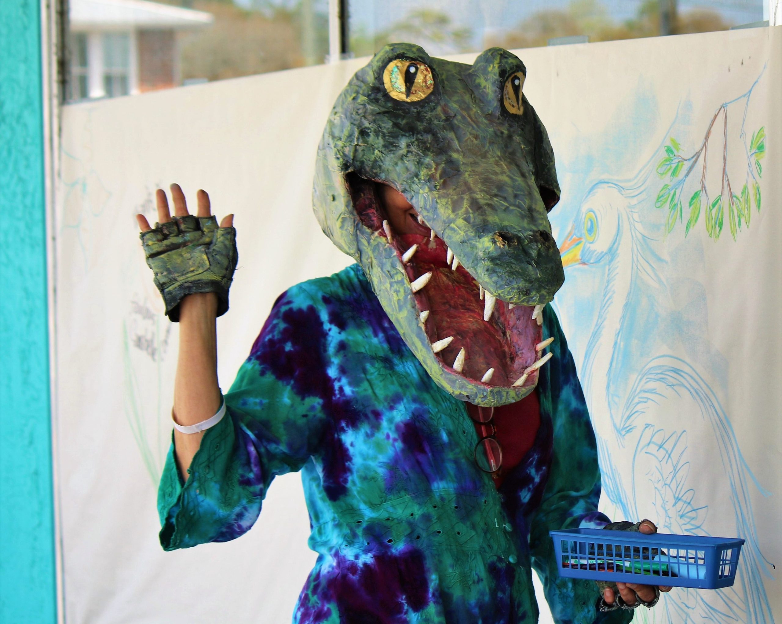 Person wearing an Alligator mask waves hiello